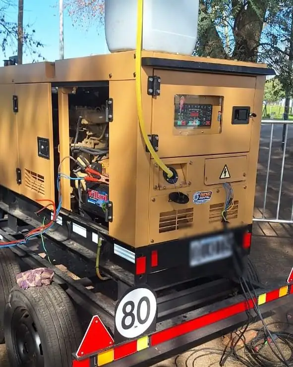Grupo electrógeno insonorizado funcionando en un evento con bidón de combustible